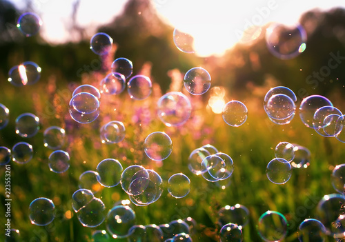 natural beautiful background with bright bubbling soap bubbles flying over bl...