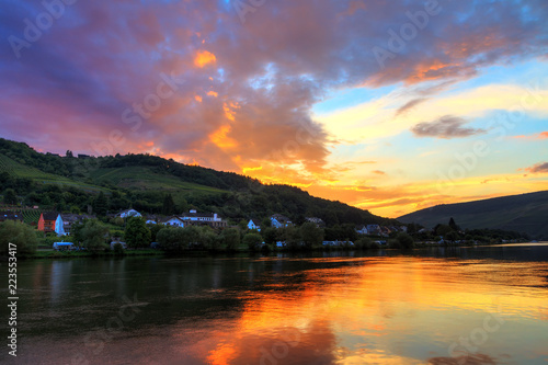 Beautiful vibrant sunset view of the river Moselle at the small wine growing town Zell (an der Mosel) with hills full of grape vines 