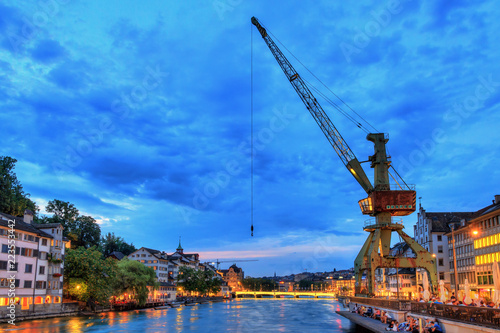 Beautiful cityscape of Zurich, Switzerland, with the crane at the river Limmat during the blue hour at night 