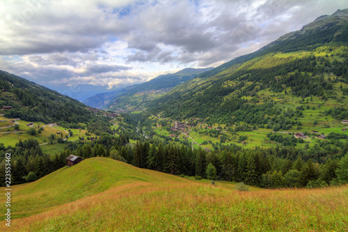 Beautiful view of the Val d’Anniviers valley in Switzerland with the villages saint-luc, saint-jean and vissoie in summer with green fields