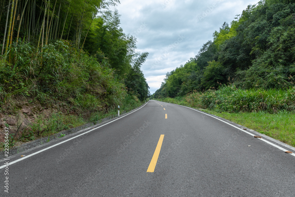 Mountain road. Landscape with rocks, sunny sky with clouds and beautiful asphalt road in the evening in summer. Vintage toning. Travel background. Highway in mountains. Transportation