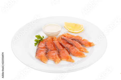 Cold appetizer before alcohol, salmon fillet salted with sauce wasabi, 6 pieces, mayonnaise, sour cream, lemon slice and parsley branch on plate, white isolated background Side view. For the menu