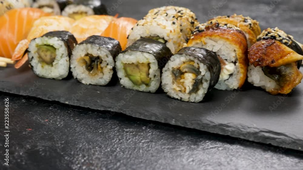 Healthy, delicious and traditional sushi rolls on black stone plate. Dolly footage Healthy, delicious and traditional sushi rolls on black stone plate. Dolly footage
