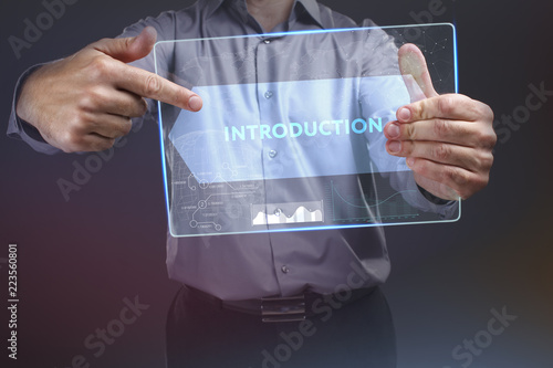 The concept of business, technology, the Internet and the network. A young entrepreneur working on a virtual screen of the future and sees the inscription: introduction photo