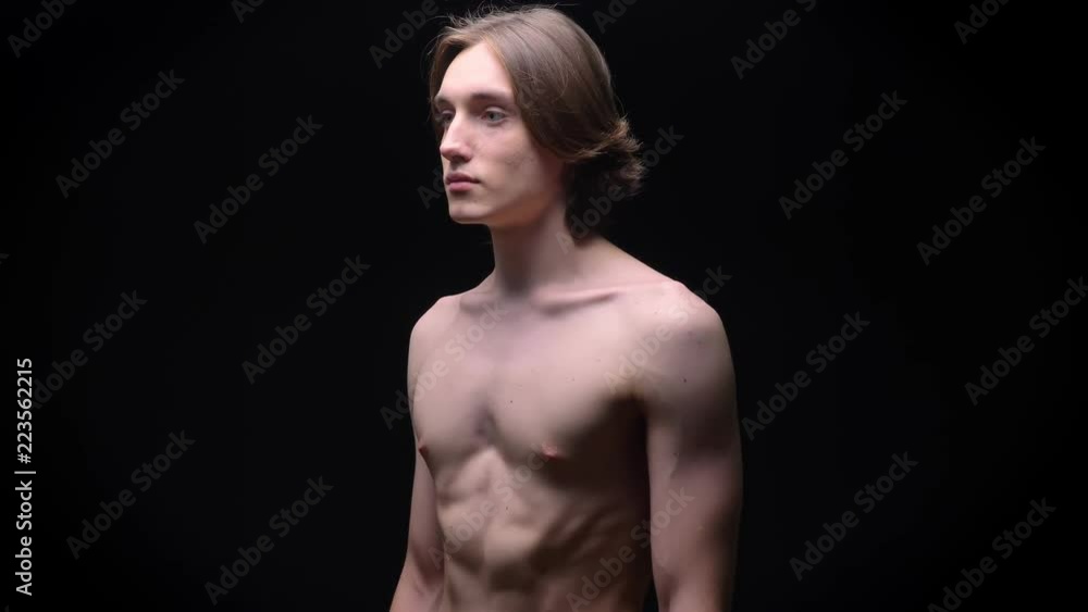 muscular strong caucasian naked boy breathing and standing calm with black background beside muscular strong caucasian naked boy breathing and standing calm with black background beside