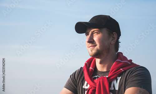 Young man looking forward against the blue sky background