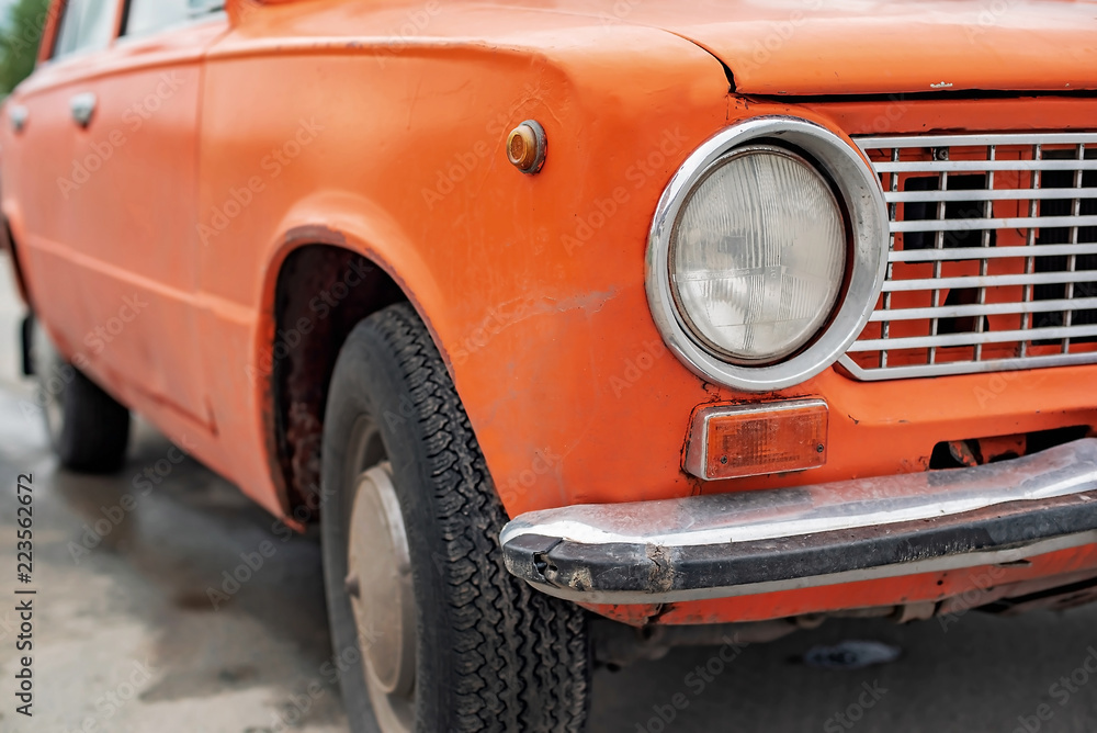 Retro orange car, old rusty machine, foreground close-up Retro orange car, old rusty machine, foreground close-up
