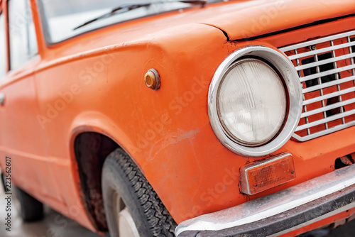 Retro orange car, old rusty machine, foreground close-up