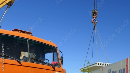 The mobile crane lifts the concrete slab into the air