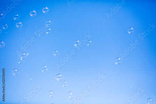 Soap bubbles in flight against the blue sky