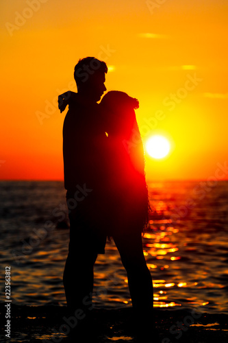 Loving couple at the sea at sunset