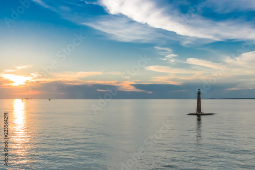 Sunset clouds and lighthouse in the bay