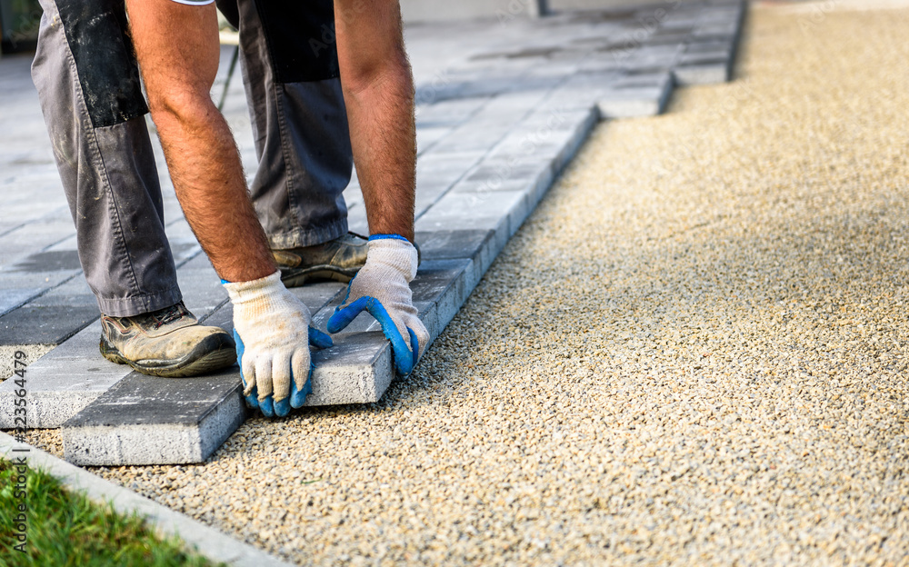 Laying gray concrete paving slabs in house courtyard driveway patio. Laying gray concrete paving slabs in house courtyard driveway patio.