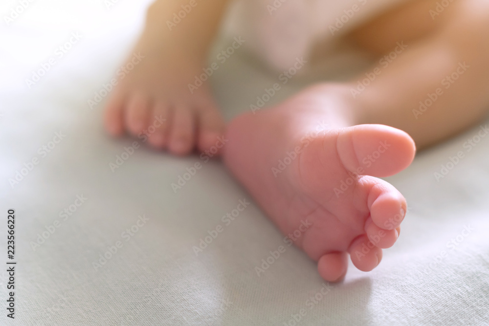 little tiny feet and toes of happy newborn baby sleeping in the baby bed in the morning sunlight. family and healthy baby concept. selective focus and soft tone photo. little tiny feet and toes of happy newborn baby sleeping in the baby bed in the morning sunlight. family and healthy baby concept. selective focus and soft tone photo.