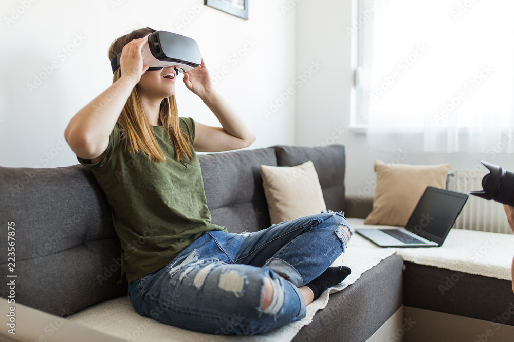 Beautiful young woman enjoying virtual reality at her home. Beautiful young woman enjoying virtual reality at her home.