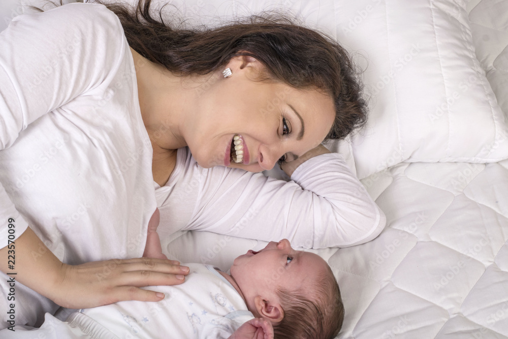 Mother and baby on a white bed Mother and baby on a white bed