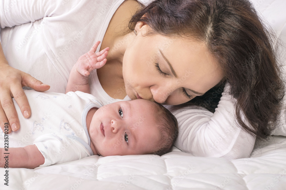 Mother and baby on a white bed Mother and baby on a white bed