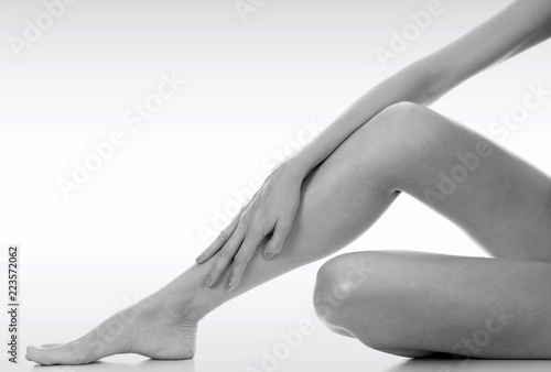 Closeup shot of beautiful female legs and hands. Unwanted hair removal concept