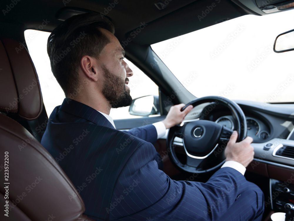 businessman sits at the wheel in his car and looks at the road businessman sits at the wheel in his car and looks at the road