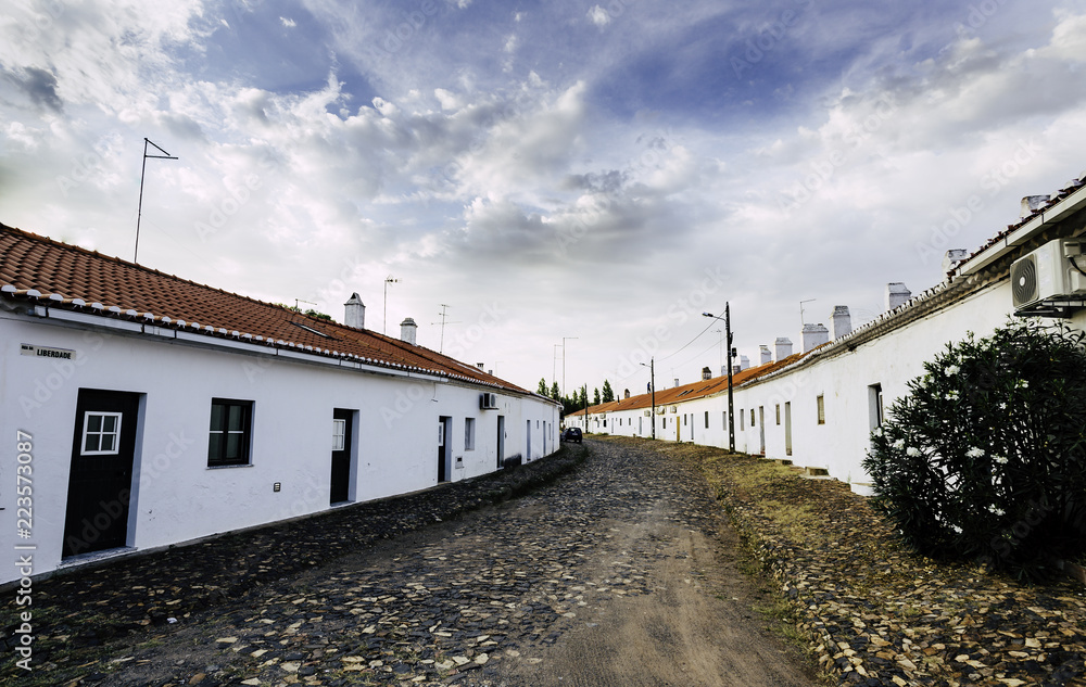 Stoned street with white facades and chimneys Stoned street with white facades and chimneys