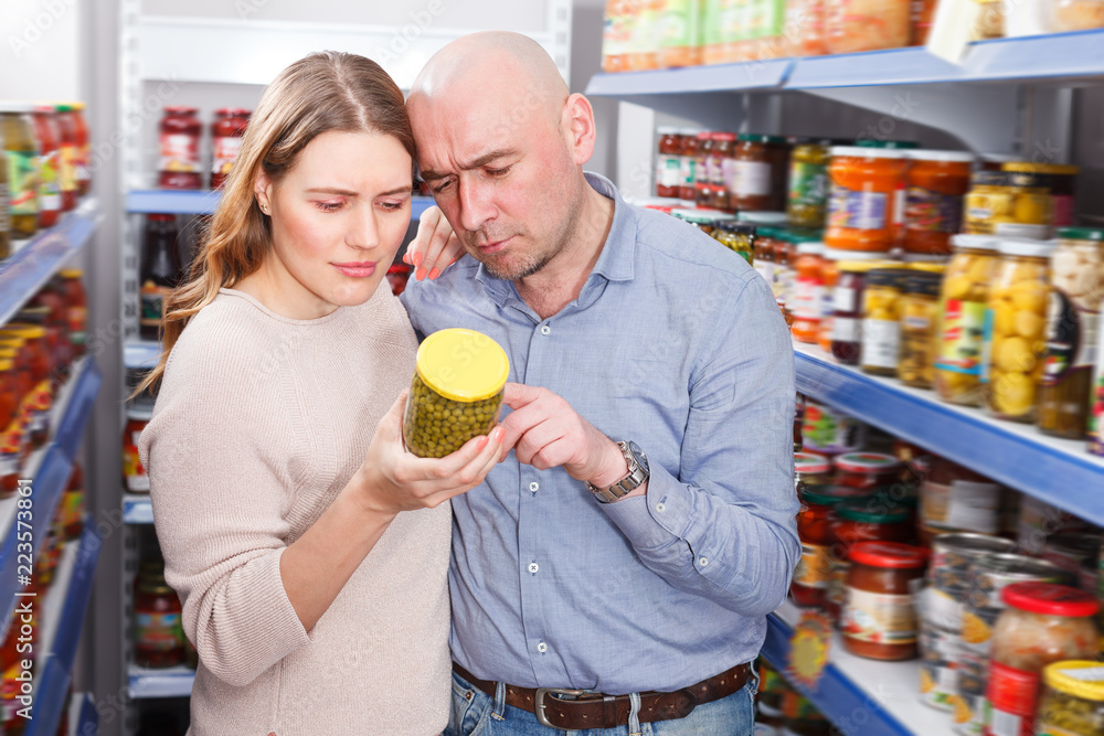 Adult couple choosing preserved goods