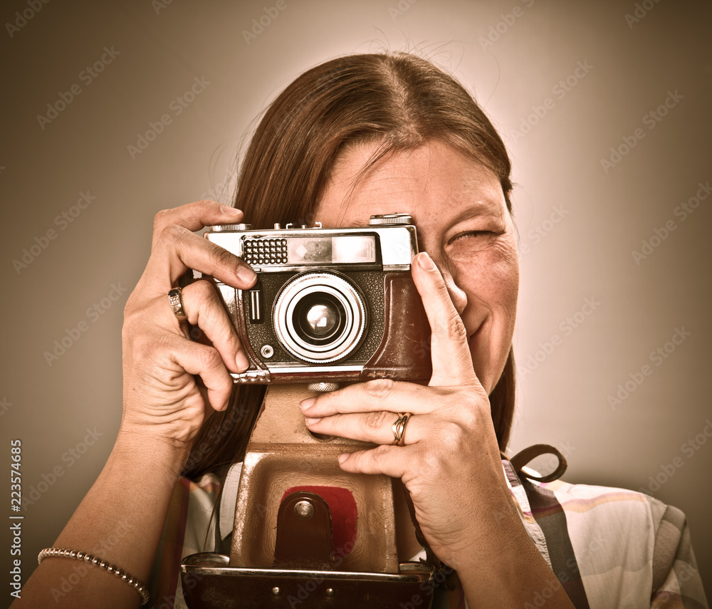 Woman with old camera isolated on grey background Woman with old camera isolated on grey background