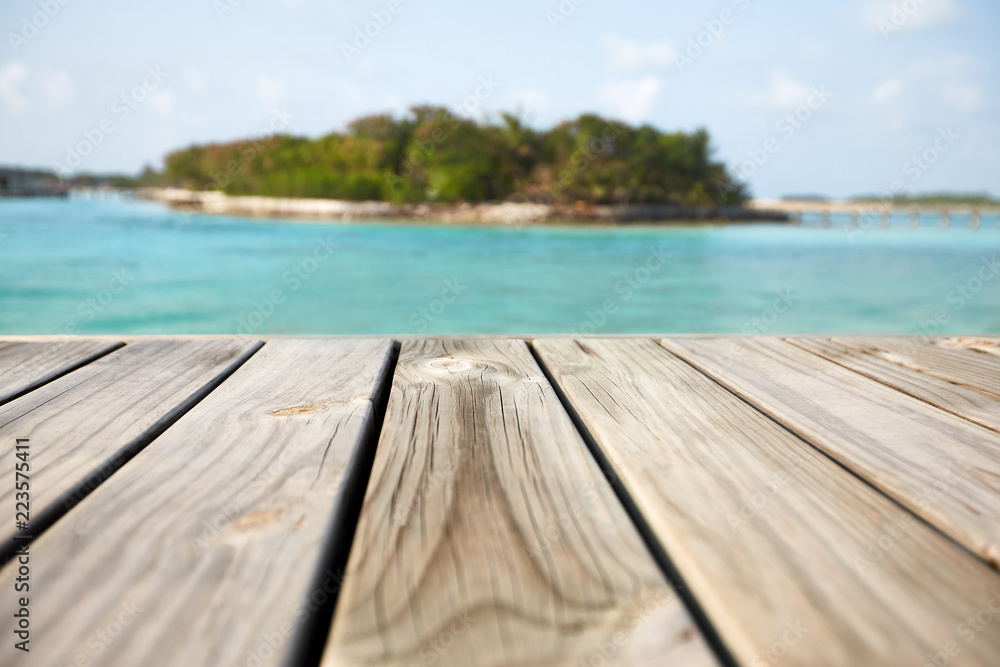 Empty white wood surface over blur blue ocean lagoon and sky and tropical for product placement and display.
