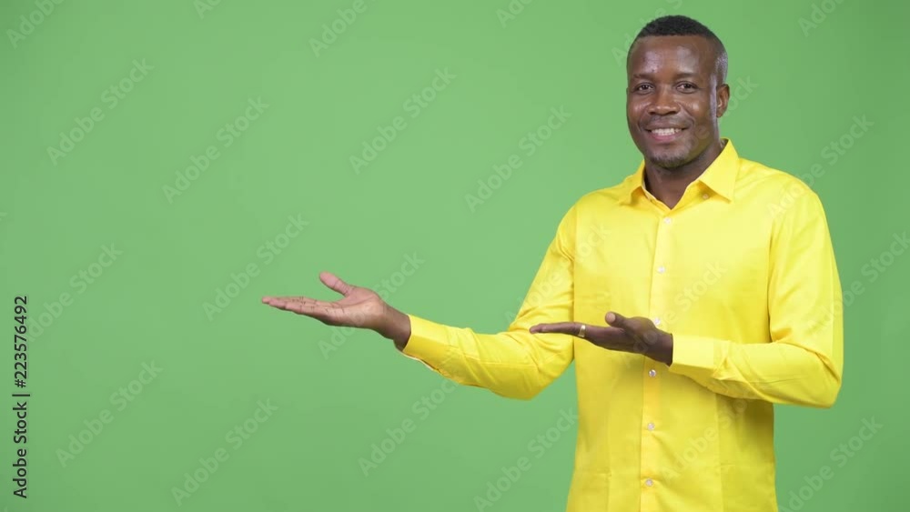 Young happy African businessman showing something Young happy African businessman showing something