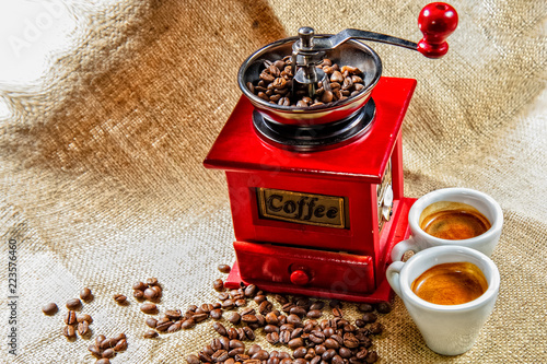 Retro manual Coffee gringer on the table with cup of coffee. photo