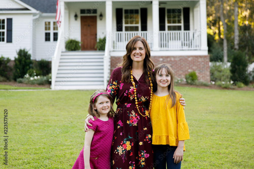 Mom and Two Daughters Hugging Outside their New Farmhouse Home Mom and Two Daughters Hugging Outside their New Farmhouse Home