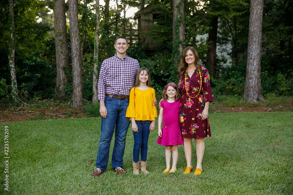 Fototapeta premium Nuclear Family of Four with Daughters Outside in their Backyard