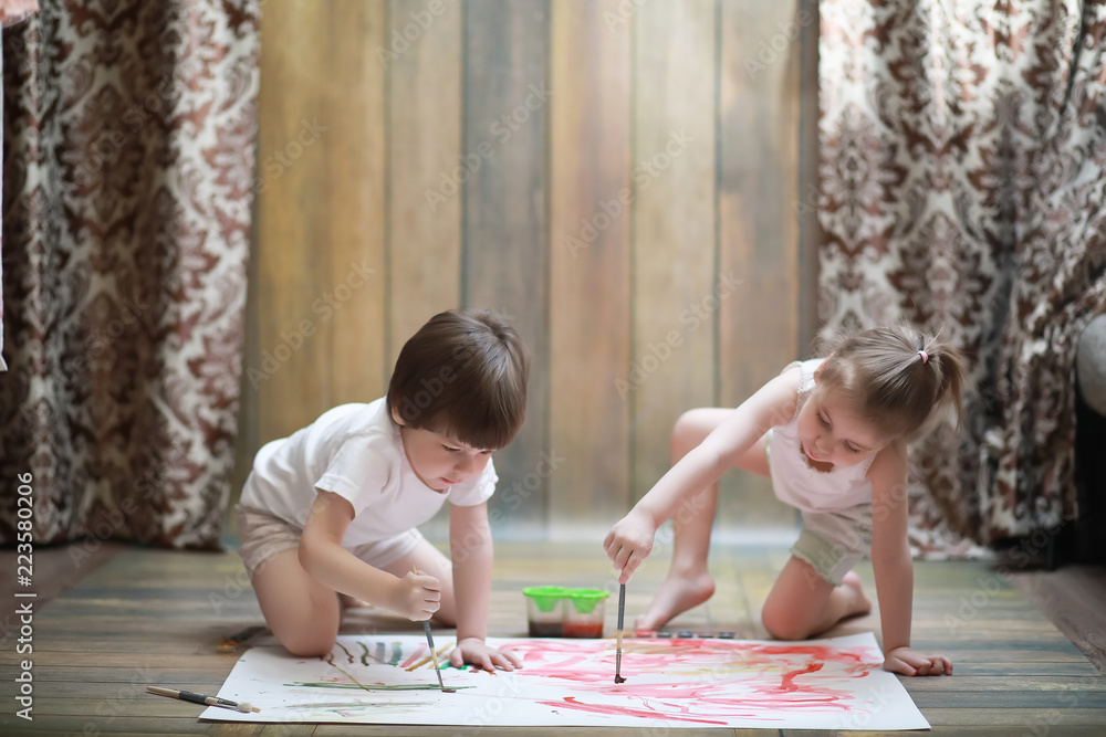 Little children paint on a large sheet of paper Little children paint on a large sheet of paper