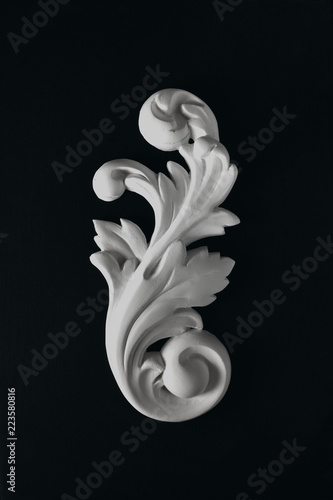 White stucco acanthus  leaf on a black background.