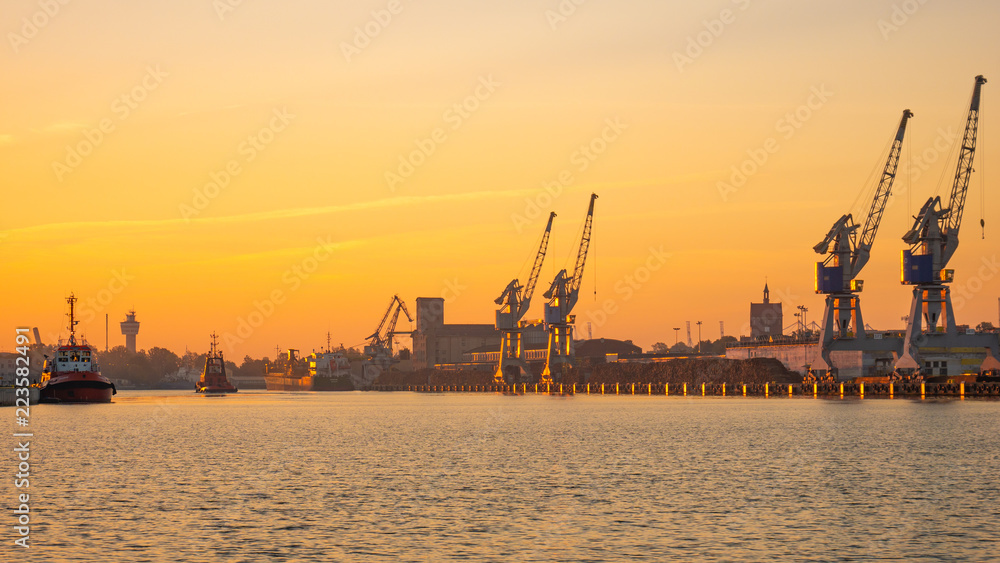 Ships in port at estuary of Vistula river at sunset time.