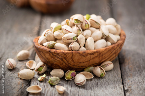 Bowl with pistachios on a wooden table. photo