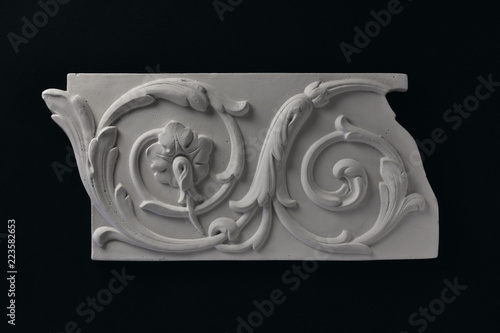 White stucco frieze and acanthus leafs witha flower.