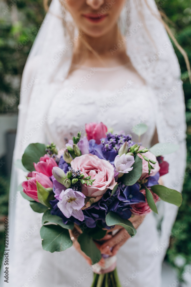 A bride in a white dress is holding a beautiful wedding bouquet. A bride in a white dress is holding a beautiful wedding bouquet.