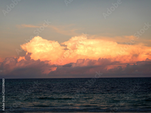 Sunset landscape at Indian ocean, big orange clouds over the water at summer