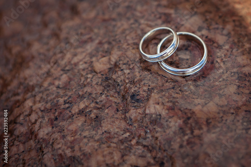 Wedding rings lie on a wet stone