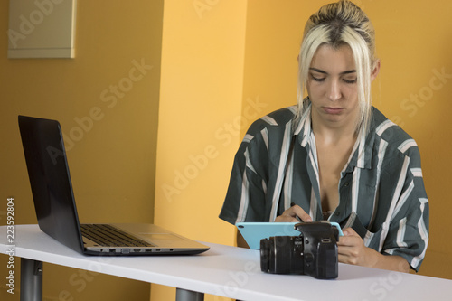 Freelancer, working with a digital tablet, camera and a laptop photo