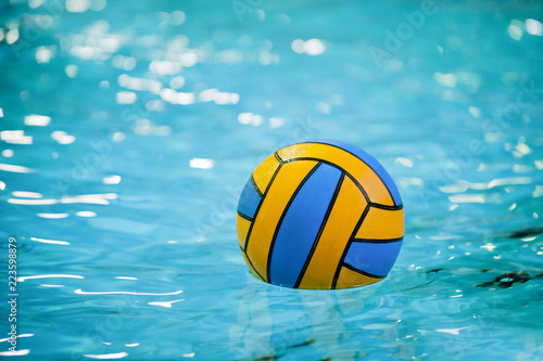 A water polo ball floating on the water in a pool.