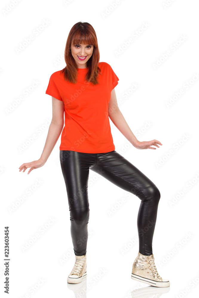Smiling Young Woman Is Standing Legs Apart And Looking At Camera Smiling Young Woman Is Standing Legs Apart And Looking At Camera