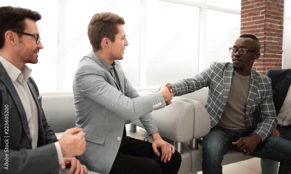 business people shaking hands sitting in the lobby of the business center business people shaking hands sitting in the lobby of the business center