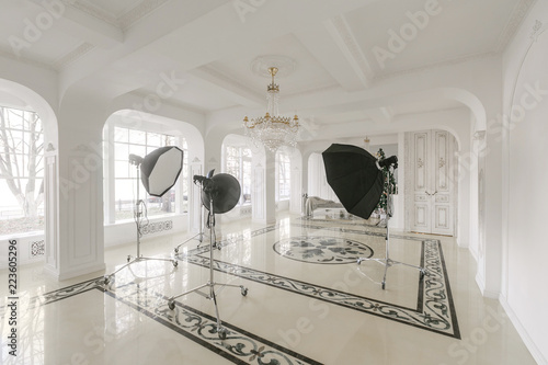 Photo Studio interior. classic luxurious apartments with a white fireplace, sofa, large windows and chandelier. photo