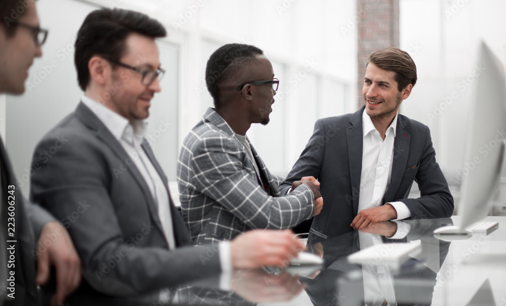handshake of young business partners at the office table handshake of young business partners at the office table