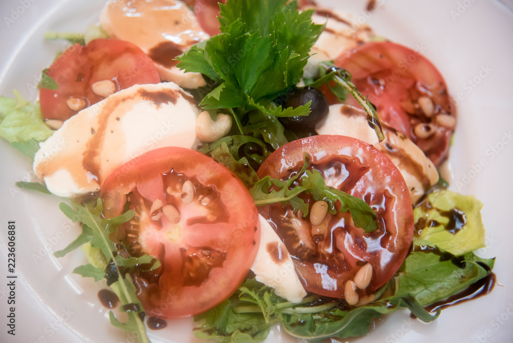 Fresh tomatoes with mozzarella, pine nuts and olives.