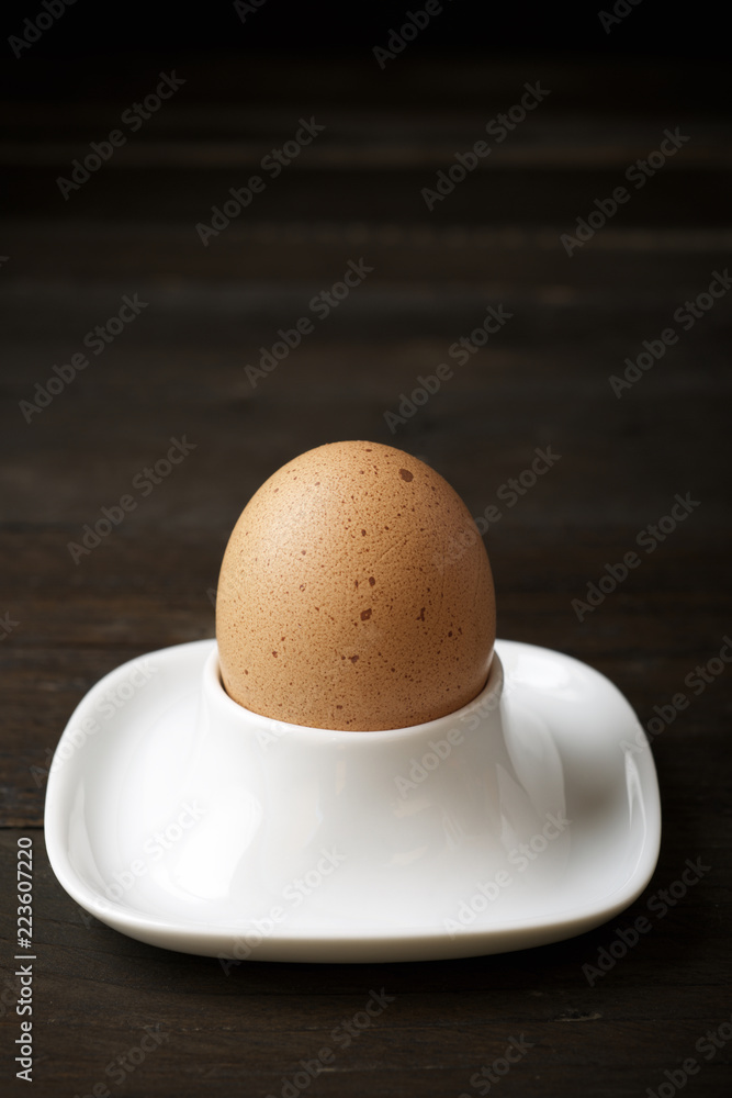 High angle close-up of brown egg in bowl on wooden table High angle close-up of brown egg in bowl on wooden table