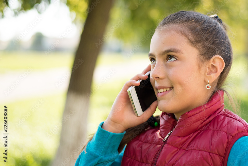 Beautiful girl talking on a smartphone in red vest Beautiful girl talking on a smartphone in red vest