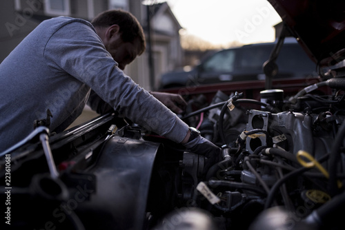 Man repairing car's engine outdoors photo