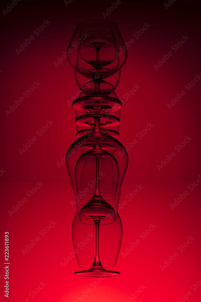 Inverted wine glasses on red background. Abstraction. Inverted wine glasses on red background. Abstraction.